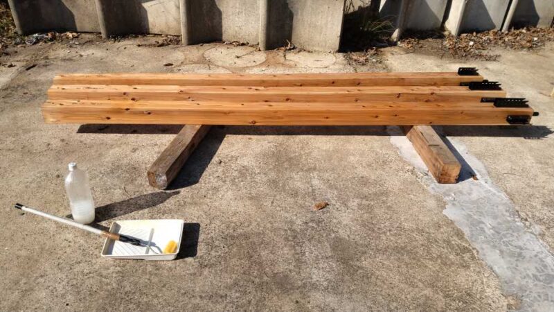 柱にローラーで防蟻剤を塗っている写真