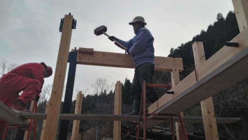 DIYで行ったプレカット金物工法の梁をカケヤで打ち込む様子